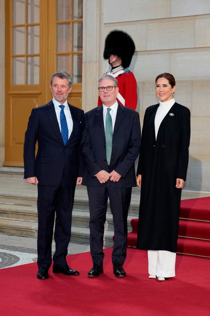 King Frederik of Denmark and Queen Mary of Denmark welcome Britain's Prime Minister Keir Starmer (C) upon arrival for a dinner for EU heads of state and government at Amalienborg Palace in Copenhagen 